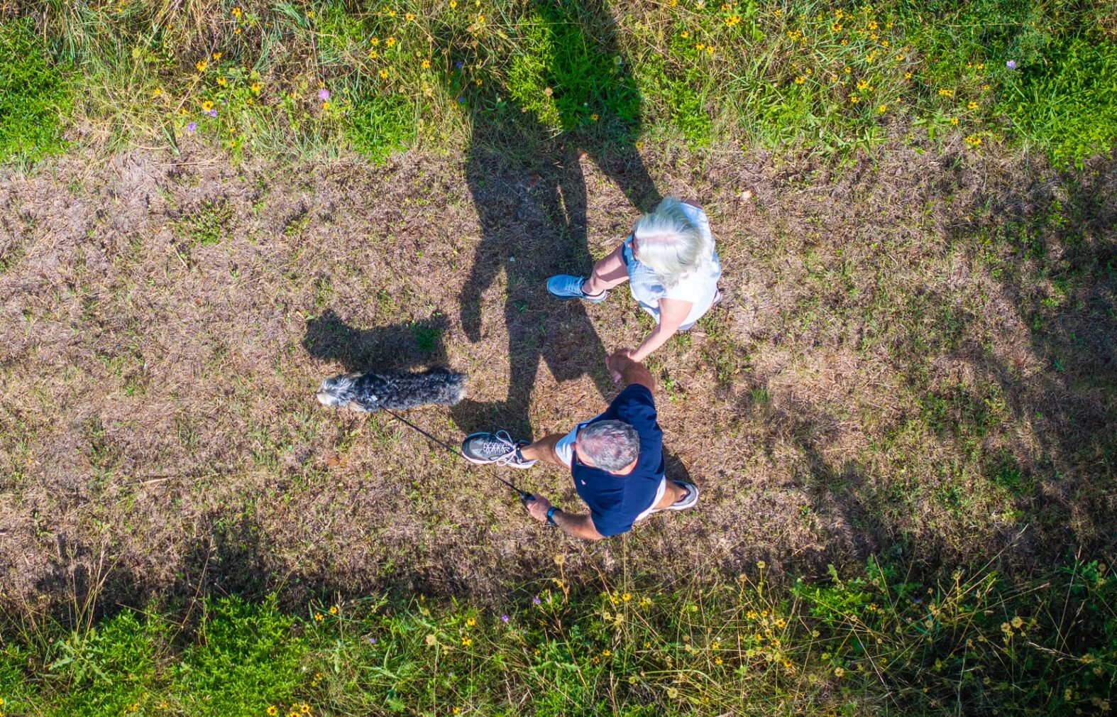 Veramendi residents in athletic clothing walking on community trail system with dirt paths and green grass